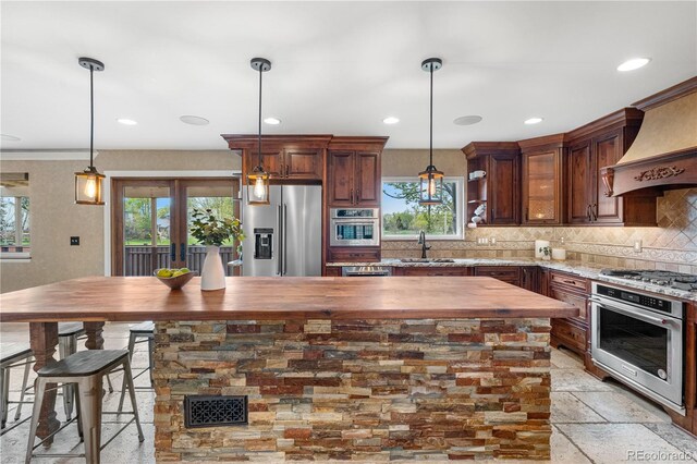 3418 Elk Ct, Broomfield, CO 80020 - kitchen featuring stainless steel appliances, butcher block counters, a sink, tasteful backsplash, and plenty of natural light