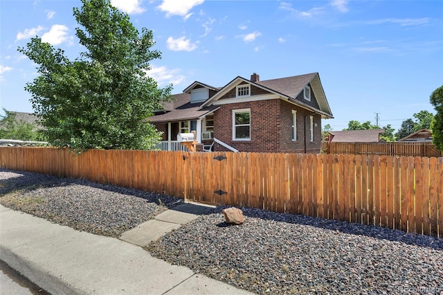 5008 Sherman St, Denver, CO 80216 - bungalow with a fenced front yard, brick siding, a chimney, and a shingled roof