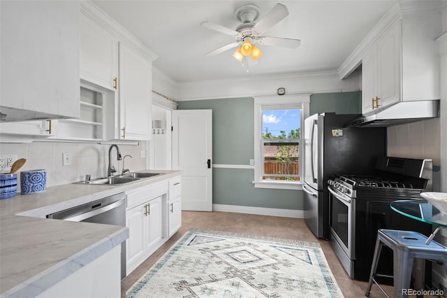 5008 Sherman St, Denver, CO 80216 - kitchen with stainless steel range with gas cooktop, under cabinet range hood, white cabinets, a ceiling fan, and ornamental molding