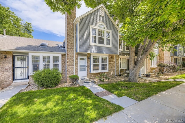 4130 E 94th Ave Unit B, Thornton, CO 80229 - view of property featuring a chimney, a front yard, and brick siding