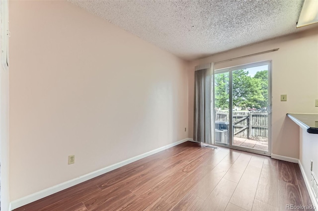 4130 E 94th Ave Unit B, Thornton, CO 80229 - spare room featuring wood finished floors and a textured ceiling