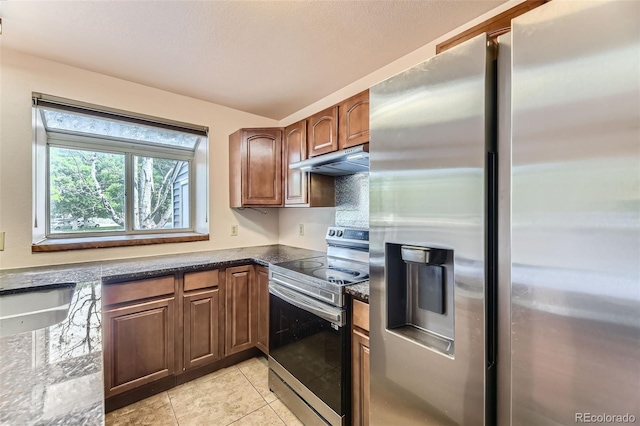 4130 E 94th Ave Unit B, Thornton, CO 80229 - kitchen with stainless steel appliances, under cabinet range hood, light tile patterned floors, and dark stone counters
