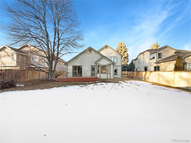 view of snow covered back of property