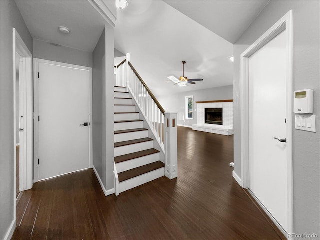 interior space featuring ceiling fan, dark hardwood / wood-style floors, and a fireplace