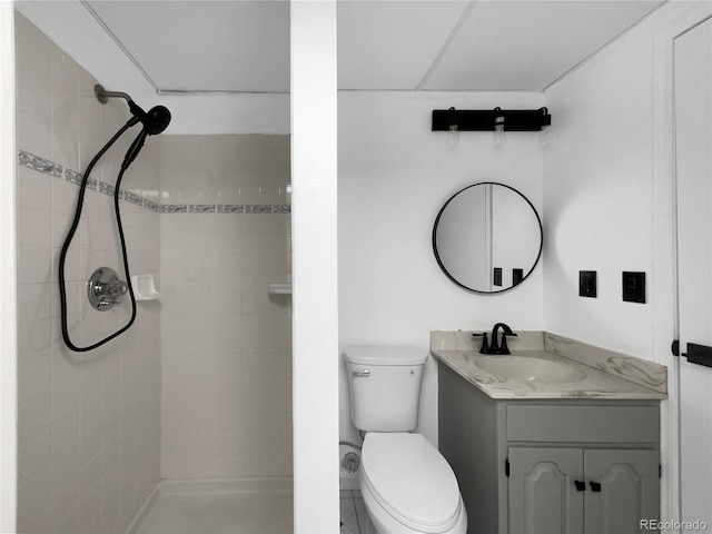 bathroom featuring vanity, toilet, and tiled shower