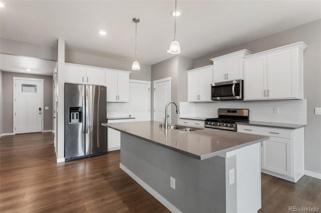 2248 Rosette Ln, Castle Rock, CO 80104 - kitchen with appliances with stainless steel finishes, an island with sink, backsplash, dark wood-type flooring, and white cabinetry
