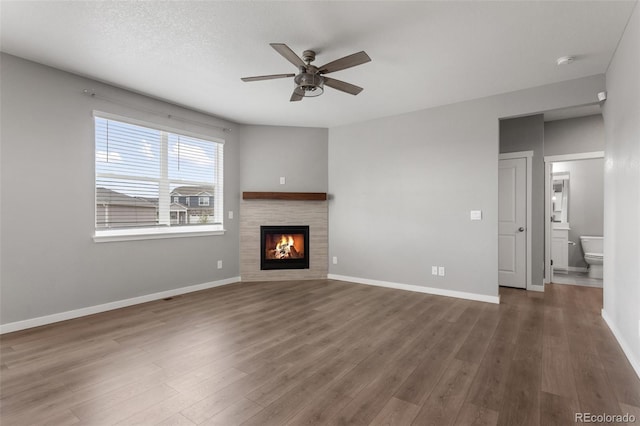2248 Rosette Ln, Castle Rock, CO 80104 - unfurnished living room with a ceiling fan, wood finished floors, and a tile fireplace