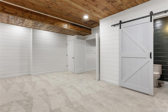 2248 Rosette Ln, Castle Rock, CO 80104 - basement with wooden ceiling, a barn door, wooden walls, carpet floors, and recessed lighting