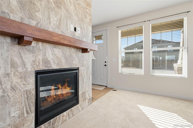 details featuring visible vents, baseboards, carpet floors, and a tile fireplace