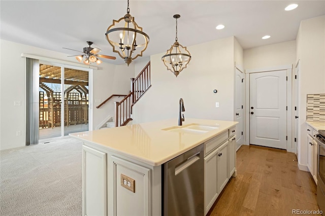 kitchen featuring pendant lighting, a kitchen island with sink, ceiling fan with notable chandelier, sink, and appliances with stainless steel finishes