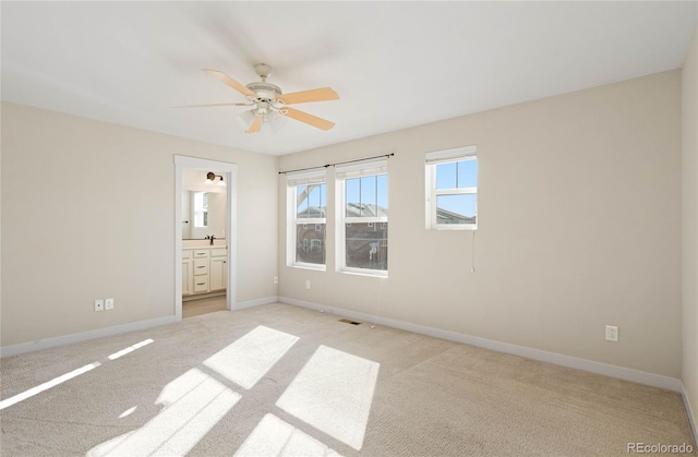 unfurnished bedroom with visible vents, baseboards, ceiling fan, light carpet, and connected bathroom