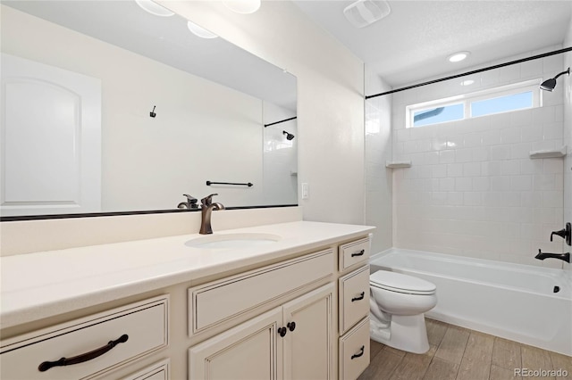 bathroom featuring visible vents, toilet, wood finished floors,  shower combination, and vanity