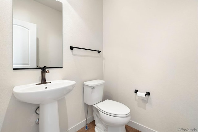 bathroom with toilet and baseboards