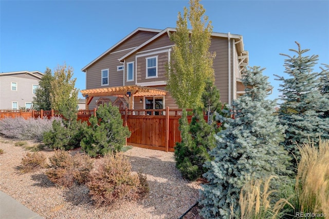 view of front of home with a pergola and fence