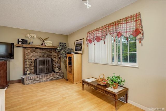 9642 Meade Ct, Westminster, CO 80031 - living area featuring wood finished floors, a textured ceiling, and a fireplace