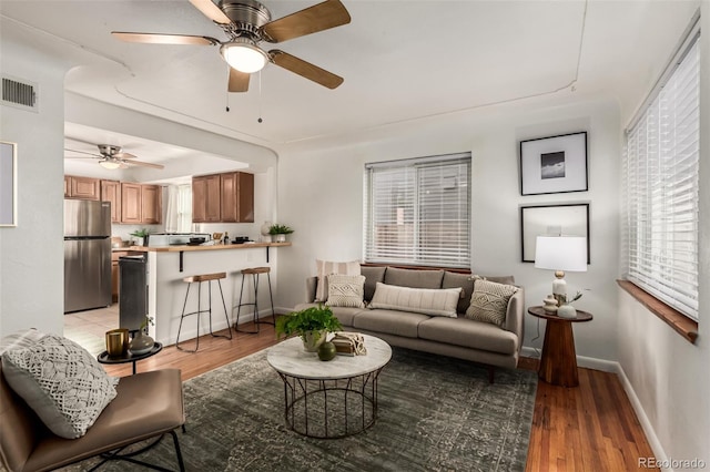 living room with ceiling fan and light hardwood / wood-style floors