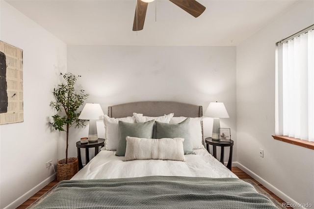 bedroom featuring multiple windows, hardwood / wood-style flooring, and ceiling fan