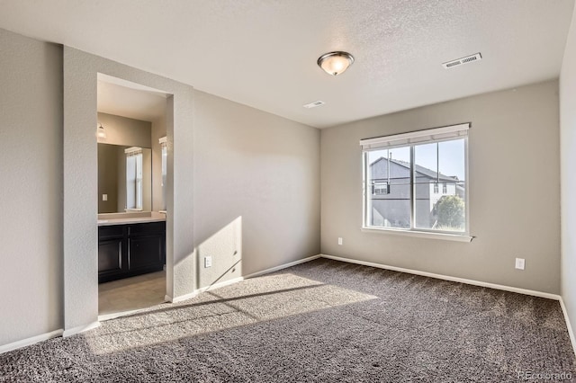 4406 Sidewinder Loop, Castle Rock, CO 80108 - unfurnished bedroom with baseboards, carpet floors, ensuite bathroom, and a textured ceiling