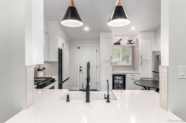 12908 Hudson St, Thornton, CO 80241 - kitchen with range, decorative backsplash, refrigerator, white cabinetry, and recessed lighting