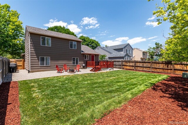 12908 Hudson St, Thornton, CO 80241 - back of property featuring a fire pit, a fenced backyard, a patio, a deck, and roof with shingles