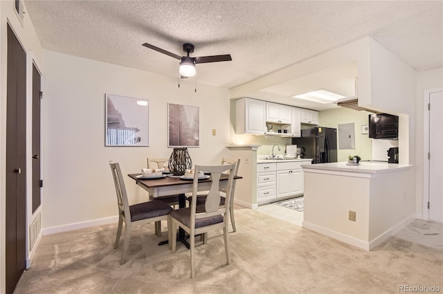 dining room featuring baseboards, light carpet, a textured ceiling, and a ceiling fan