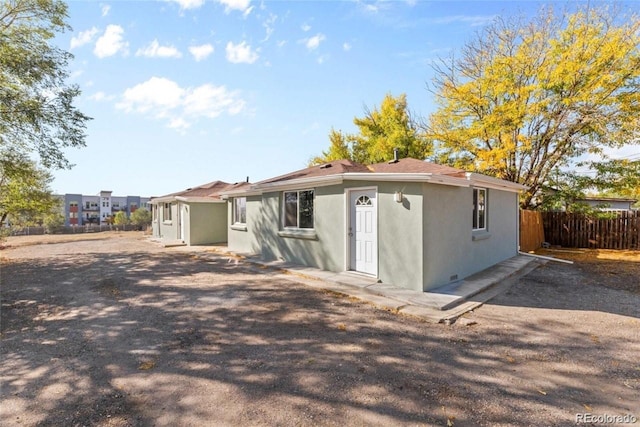 3464 W 65th Ave, Denver, CO 80221 - rear view of house with fence and stucco siding