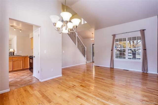 interior space featuring lofted ceiling, a chandelier, and light hardwood / wood-style floors