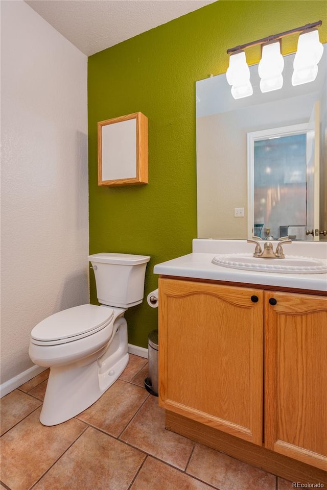 bathroom featuring tile patterned floors, vanity, and toilet