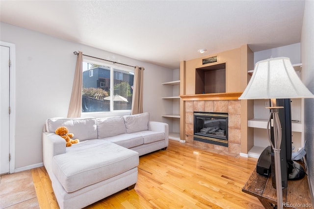 living room featuring a fireplace, light hardwood / wood-style floors, and a textured ceiling