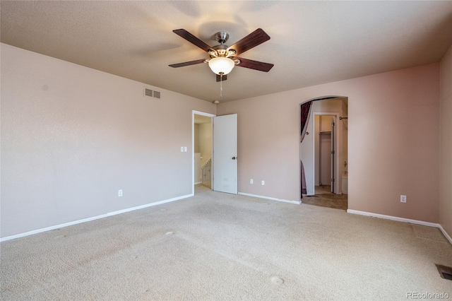 unfurnished bedroom featuring ensuite bathroom, ceiling fan, and light colored carpet