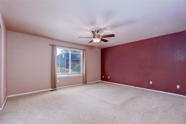 carpeted empty room featuring ceiling fan and a textured ceiling