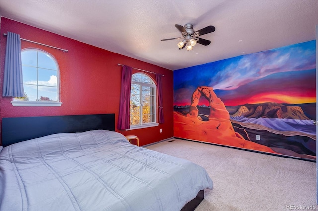 bedroom featuring ceiling fan, light colored carpet, and a textured ceiling