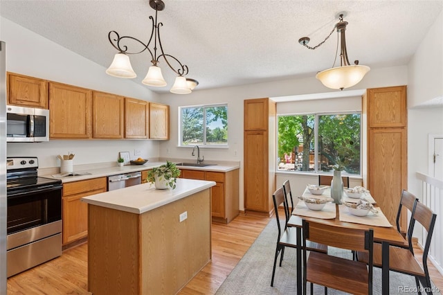 17611 Hoyt Pl, Parker, CO 80134 - kitchen with stainless steel appliances, a sink, a textured ceiling, light countertops, and a kitchen island