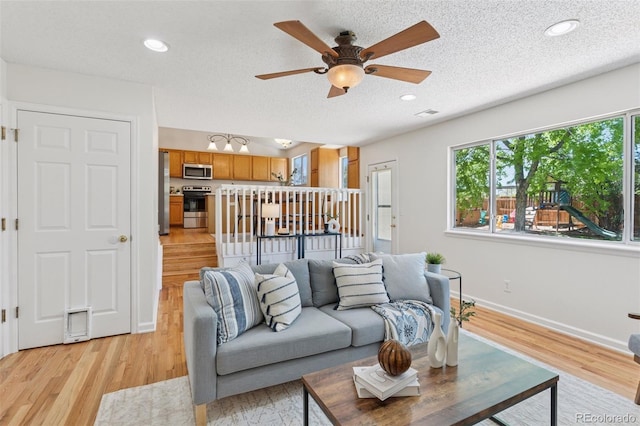17611 Hoyt Pl, Parker, CO 80134 - living area with a ceiling fan, baseboards, light wood-type flooring, a textured ceiling, and recessed lighting