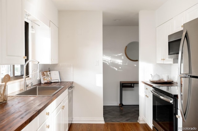 3004 S Niagara Way, Denver, CO 80224 - kitchen featuring stainless steel appliances, wooden counters, backsplash, and white cabinets