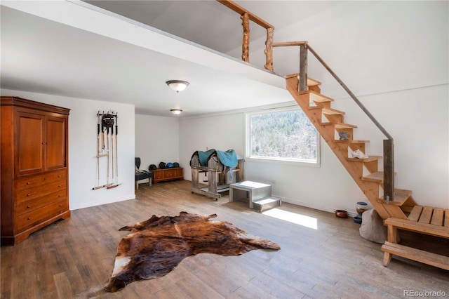 sitting room with stairs, baseboards, and wood finished floors