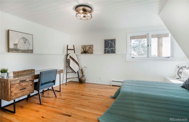bedroom with baseboards, light wood-style flooring, and baseboard heating