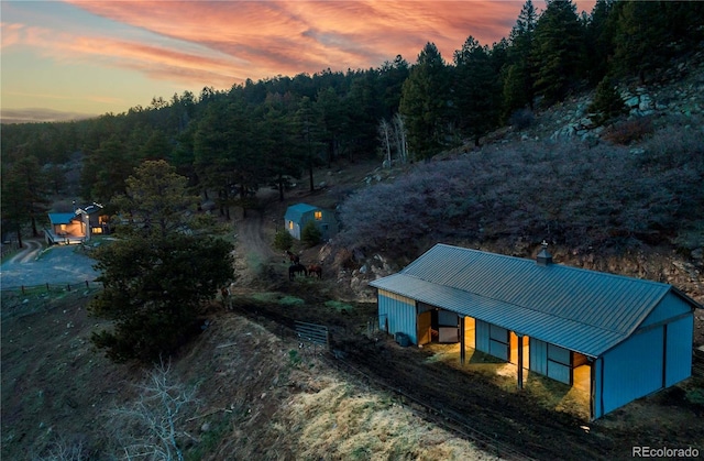 aerial view at dusk with a wooded view