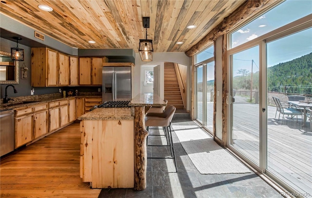 kitchen with light brown cabinetry, a center island, a sink, wooden ceiling, and stainless steel appliances