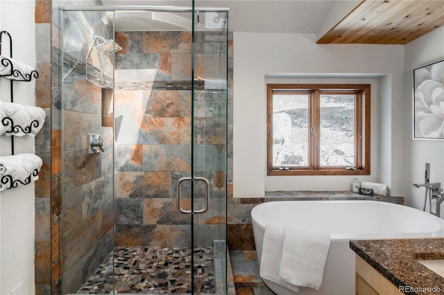 full bathroom with a freestanding bath, vanity, and a stall shower