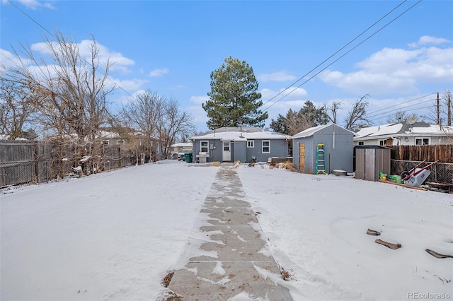 snow covered property with a storage unit