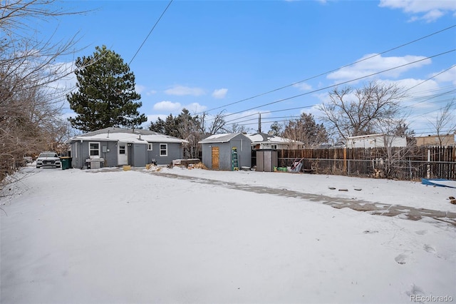 snowy yard featuring a storage unit