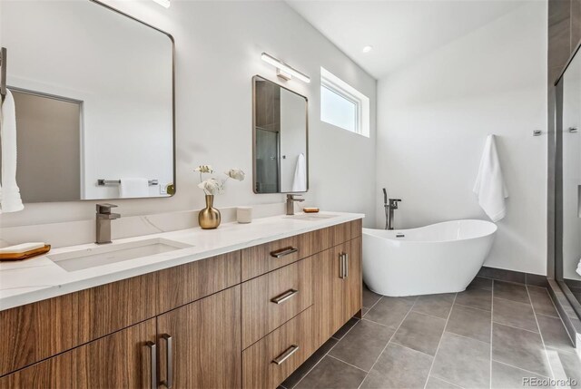 bathroom featuring plus walk in shower, vaulted ceiling, tile patterned floors, and vanity