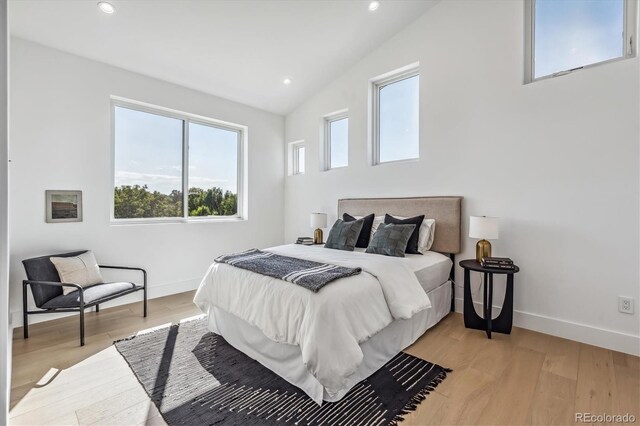 bedroom with lofted ceiling and light hardwood / wood-style flooring