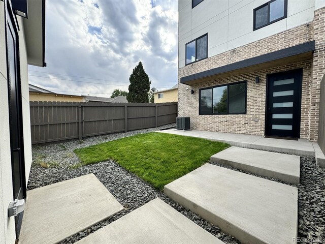 view of yard with central AC unit and a patio area