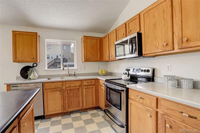 kitchen featuring plenty of natural light, a textured ceiling, stainless steel appliances, and a sink