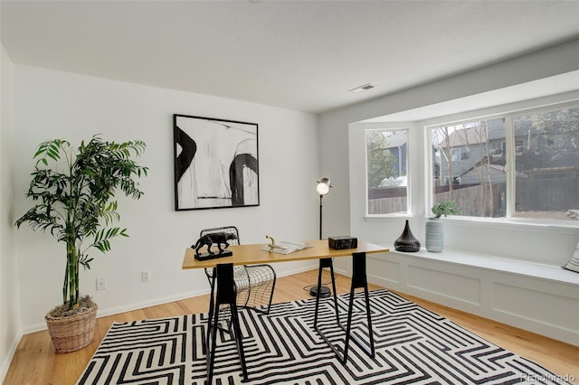 home office featuring light wood-style flooring and visible vents
