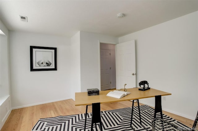 home office with baseboards, wood finished floors, and visible vents