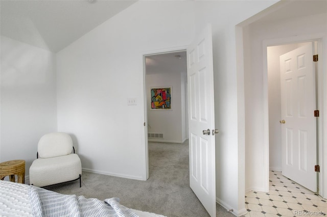 bedroom featuring vaulted ceiling, visible vents, baseboards, and light carpet