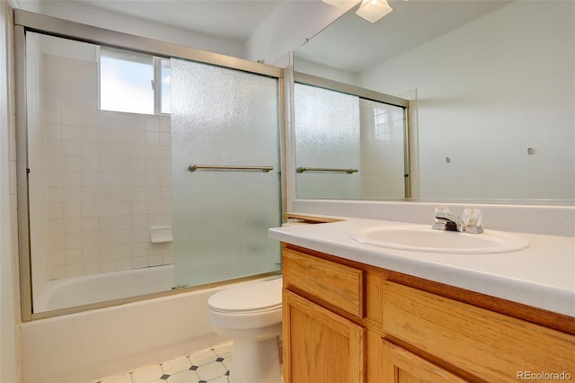 bathroom with toilet, vanity, and enclosed tub / shower combo